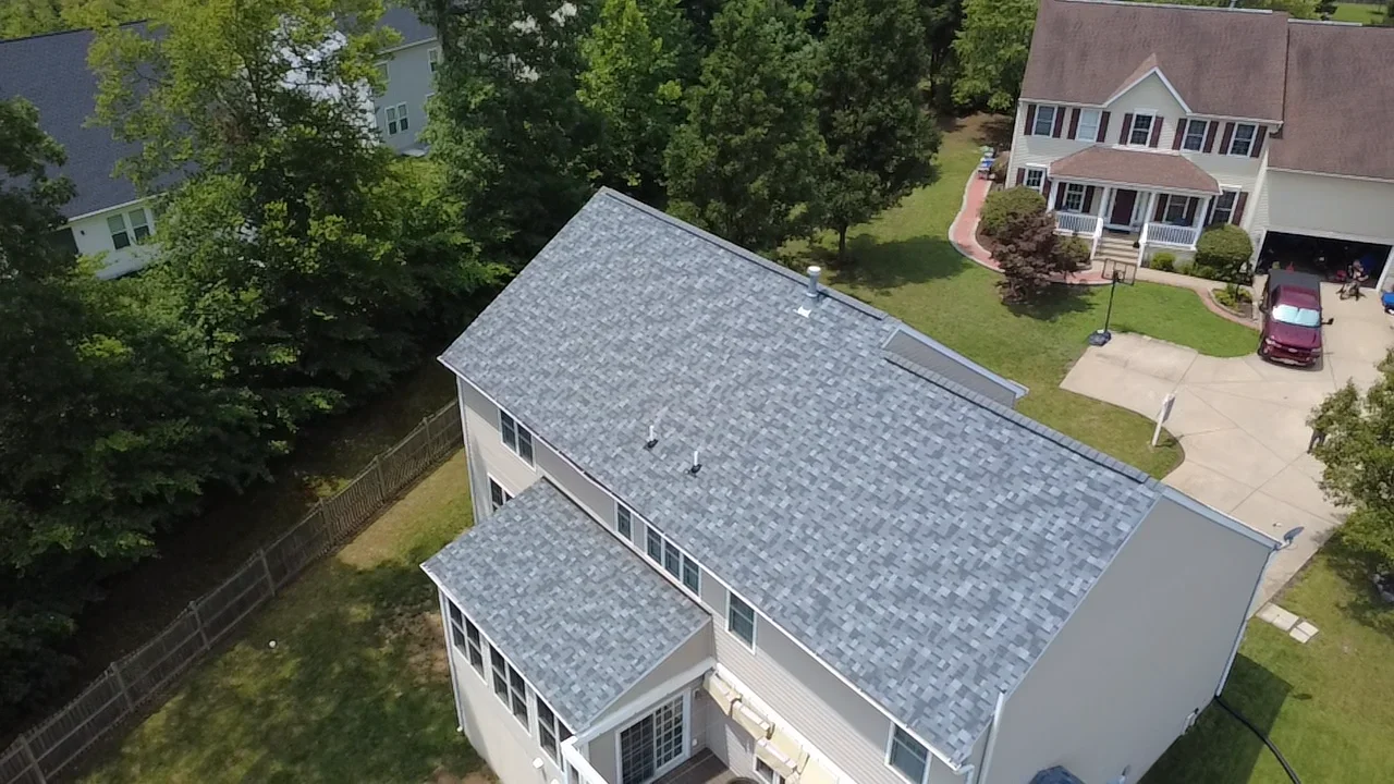Gray architectural shingle roof installation on two-story home with multiple roof planes