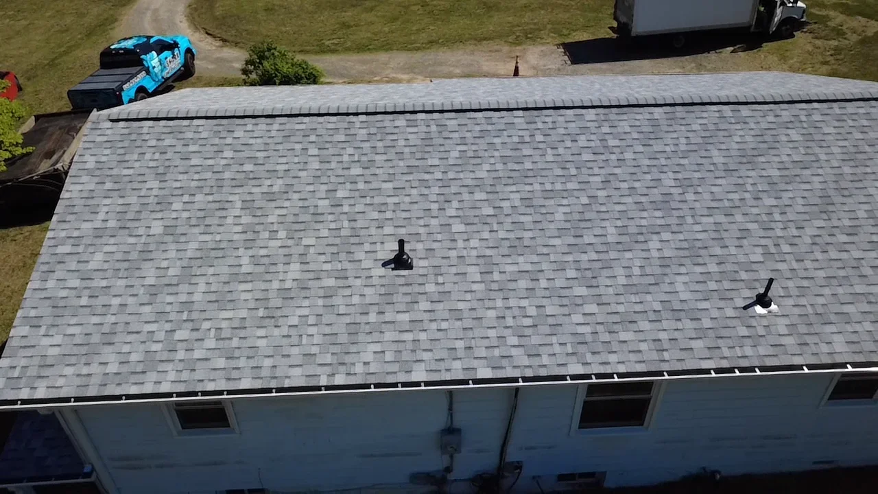 Gray architectural shingles with ridge caps and roof vents on residential home